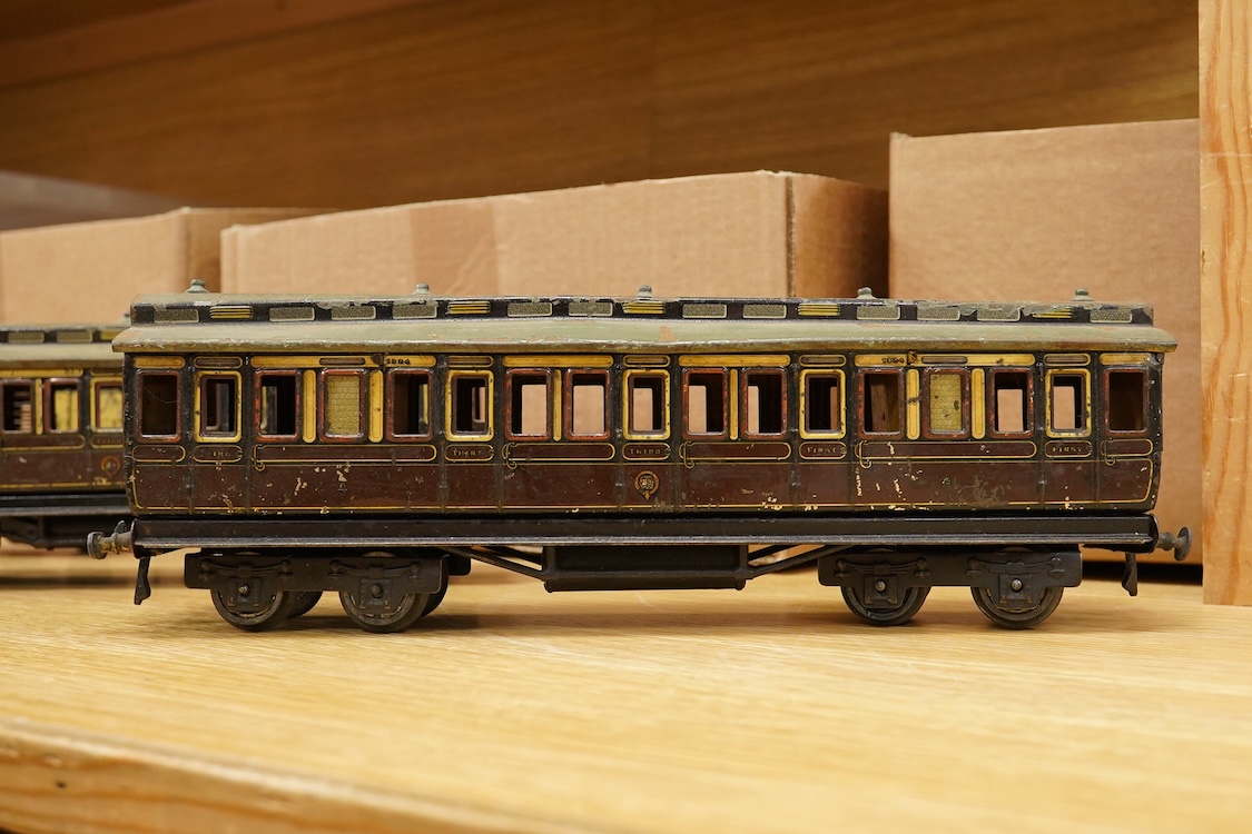 Three Carette for Bassett-Lowke 0 gauge tinplate GWR clerestory bogie coaches; two First Third Composite coaches, both 1324, and a full brake van, 1334, all in chocolate and cream livery